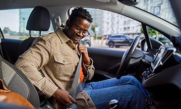 Guy buckling up in car